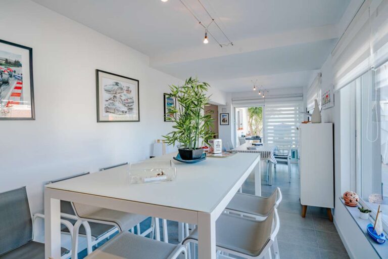 Bright dining area inside a modern villa in Calpe with large windows, white interiors and natural light