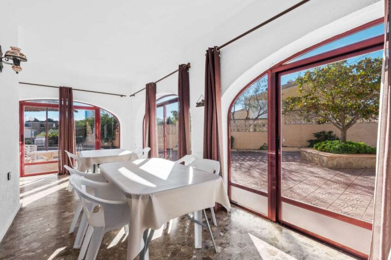 Bright dining area with arched windows and terrace views inside a spacious villa in Calpe.