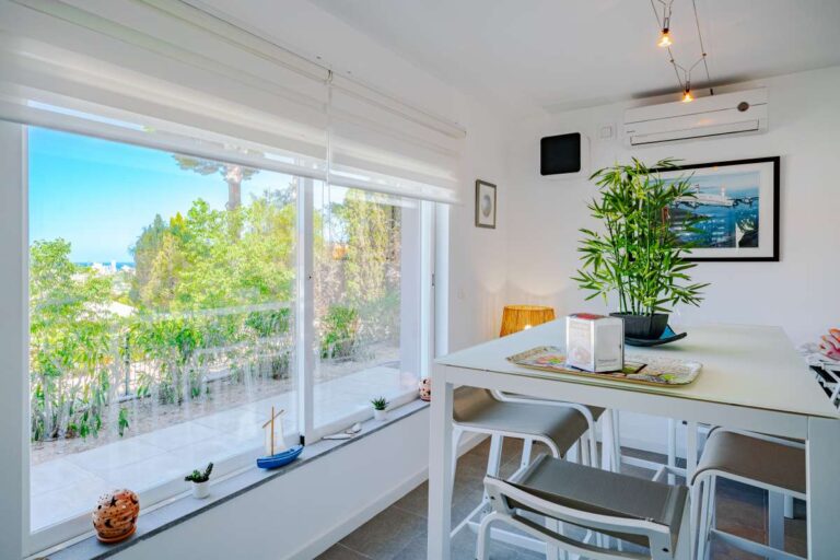Bright dining space inside a modern villa in Calpe with large windows, garden views and natural light