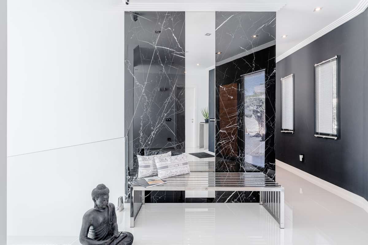 Bright entrance hall with marble staircase, glass lift and contemporary finishes inside a luxury villa in Gran Sol, Calpe.