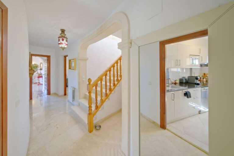 Bright hallway with staircase and kitchen entrance inside a second line Mediterranean villa near Puerto Blanco in Calpe.