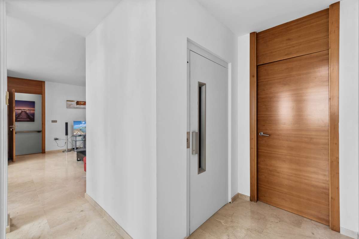 Bright interior hallway with wooden entrance door inside a modern spacious villa in Calpe.