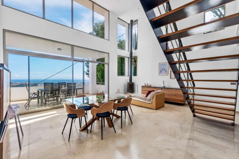 Bright living and dining area with large windows, terrace access and open views inside a modern spacious villa in Calpe.