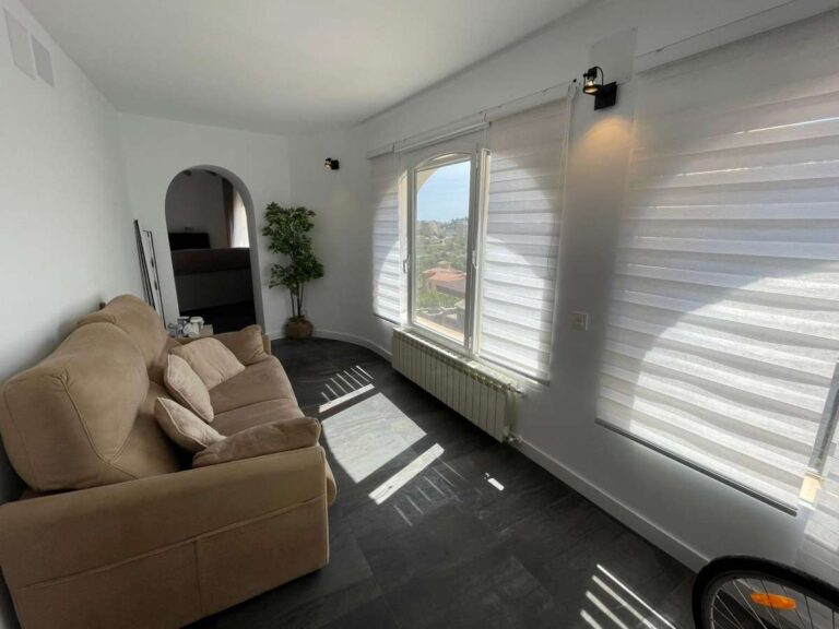 Bright living area with sofa and large windows inside a refurbished villa with sea views in Canuta, Calpe.