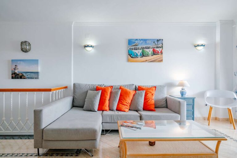 Bright living room inside a duplex apartment near Les Platgetes Beach in Moraira with sofa seating, coffee table, dining area and neutral interior finish