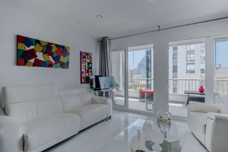 Bright living room inside a renovated apartment by Arenal-Bol Beach in Calpe with terrace access, sea views and modern white interior