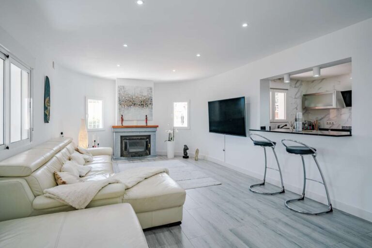 Bright living room with open-plan kitchen and breakfast bar inside a renovated Mediterranean villa in La Cometa, Calpe.