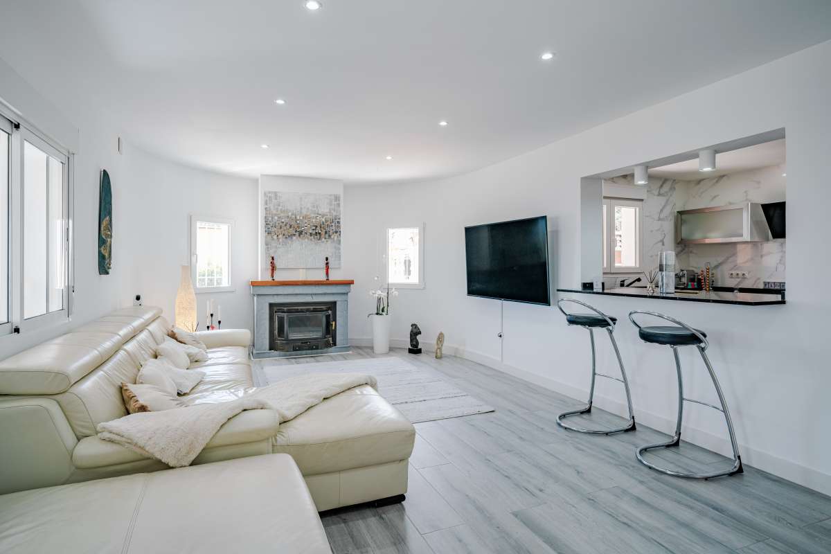 Bright living room with open-plan kitchen and breakfast bar inside a renovated Mediterranean villa in La Cometa, Calpe.