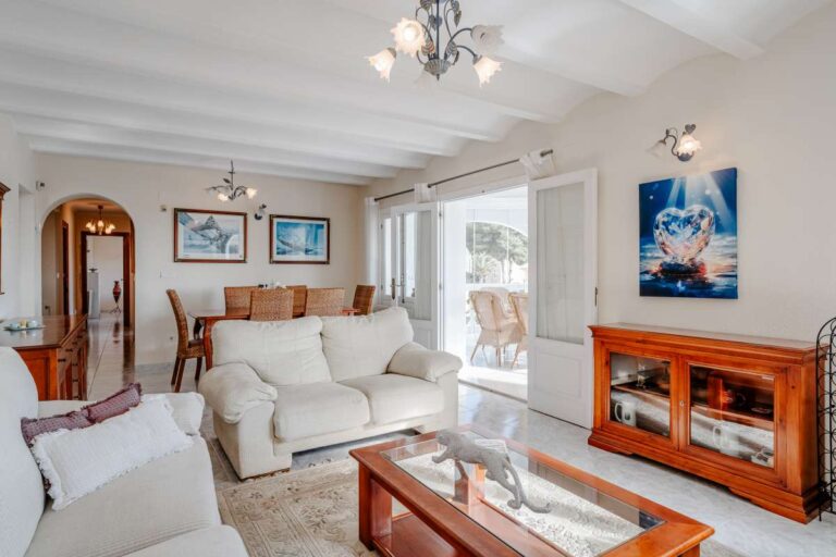 Bright living room with sofa seating, traditional furniture and terrace access inside a Mediterranean villa in Calpe.