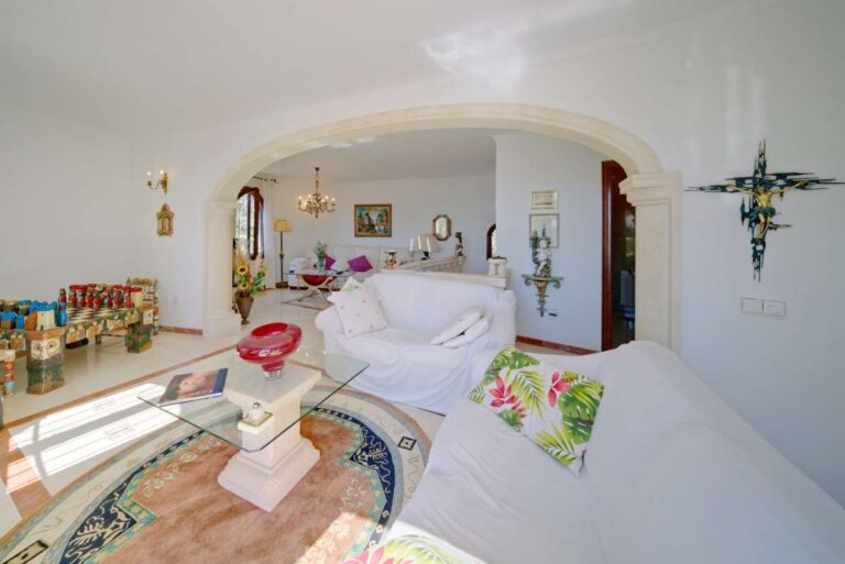 Bright living room with traditional furniture, arched opening and natural light inside a second line Mediterranean villa in Calpe.