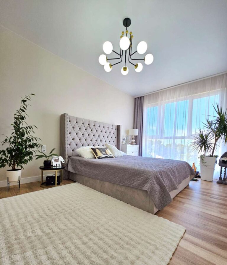 Bright main bedroom inside a modern villa near Les Bassetes in Calpe with large window, wood flooring and soft natural light