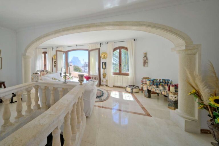 Bright upper living area with arched opening and terrace access inside a Mediterranean villa near Puerto Blanco in Calpe.