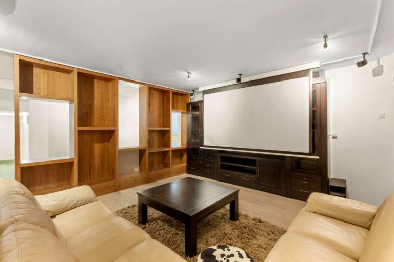 Cinema room inside a private villa in Calpe with large screen, sofa seating, fitted storage and entertainment space