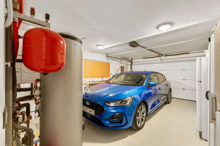 Closed garage inside a private villa in Calpe with vehicle parking, utility equipment and storage space