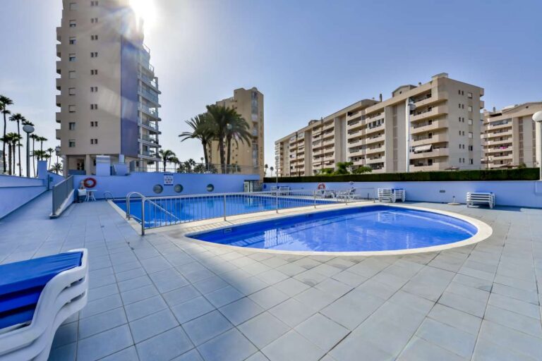 Communal pool terrace at a beachfront apartment building in La Fossa, Calpe with surrounding apartments and seating area