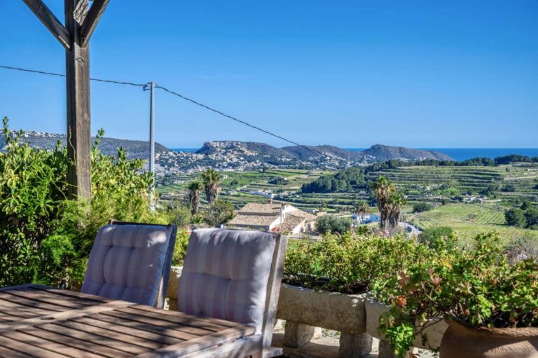 Countryside and sea views from a traditional Spanish finca near Moraira with outdoor seating, valley views and Mediterranean coastline beyond
