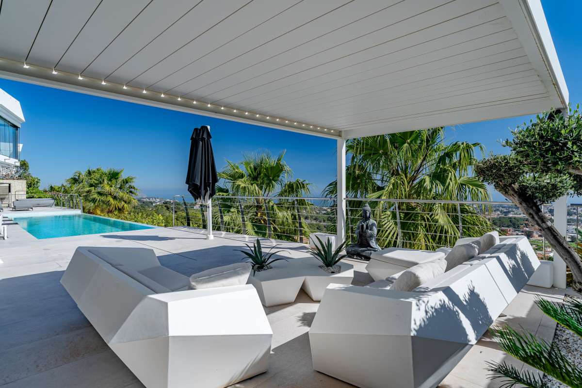 Covered chill-out terrace with lounge seating, infinity pool and panoramic sea views at a luxury villa in Gran Sol, Calpe.
