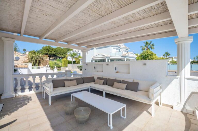 Covered lounge terrace with outdoor seating and open views at a villa in Calpe.