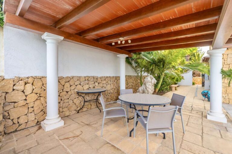 Covered outdoor dining area at a premium coastal villa on the Benissa Costa with stone walling, terrace seating and garden access