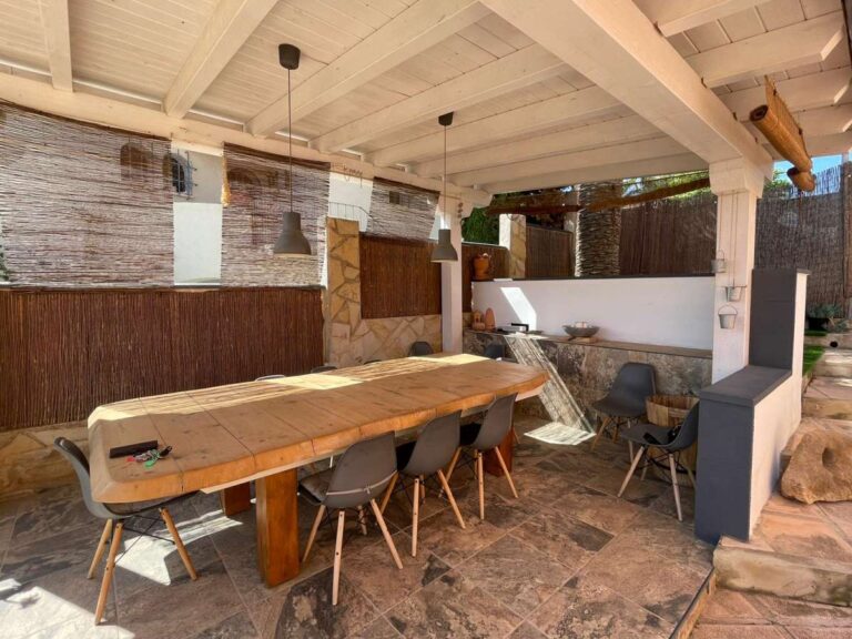 Covered outdoor dining area with large table beside the pool at a refurbished villa in Canuta, Calpe.