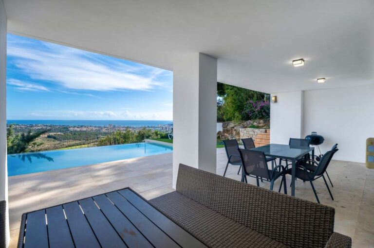 Covered outdoor lounge with panoramic sea views beside the pool at a modern spacious villa in Calpe.