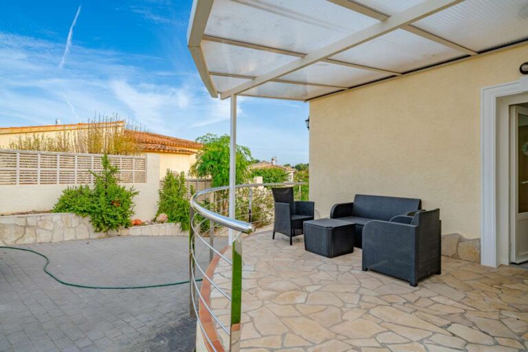 Covered outdoor terrace at a villa in Calpe with seating area and residential surroundings