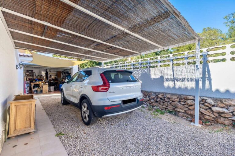 Covered parking area with vehicle access beside a contemporary villa in Calpe.