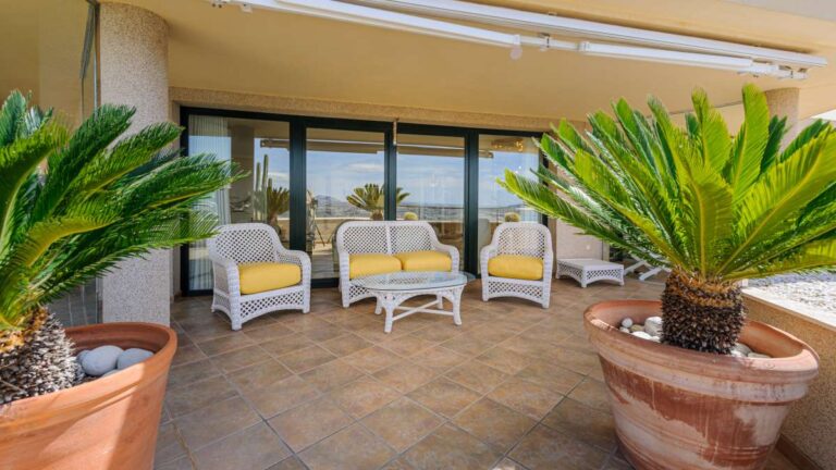 Covered terrace at a luxury apartment in Sierra de Altea with outdoor seating, potted plants, tiled flooring and mountain views