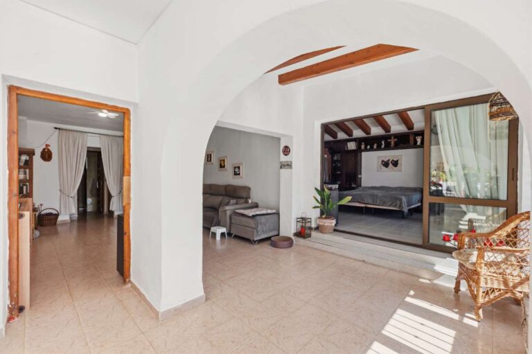 Covered terrace at a Mediterranean villa in Benissa Costa near Cala Baladrar with arched opening, seating area and bedroom access