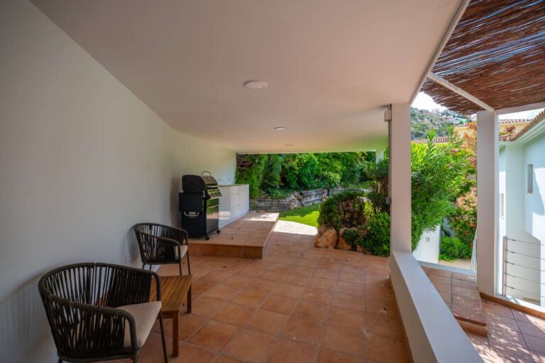Covered terrace at a modern villa in Altea Hills with outdoor seating, shaded dining area, garden views and Mediterranean surroundings