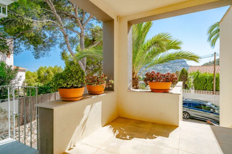 Covered terrace at a modern villa in Calpe with seating area, potted plants and mountain views