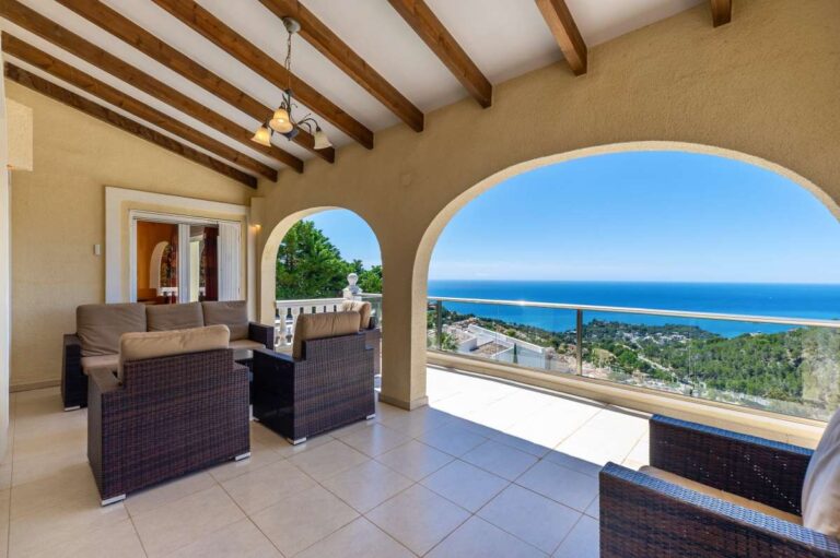 Covered terrace at an elegant Mediterranean villa in Altea Hills with outdoor seating, arched openings and panoramic sea views