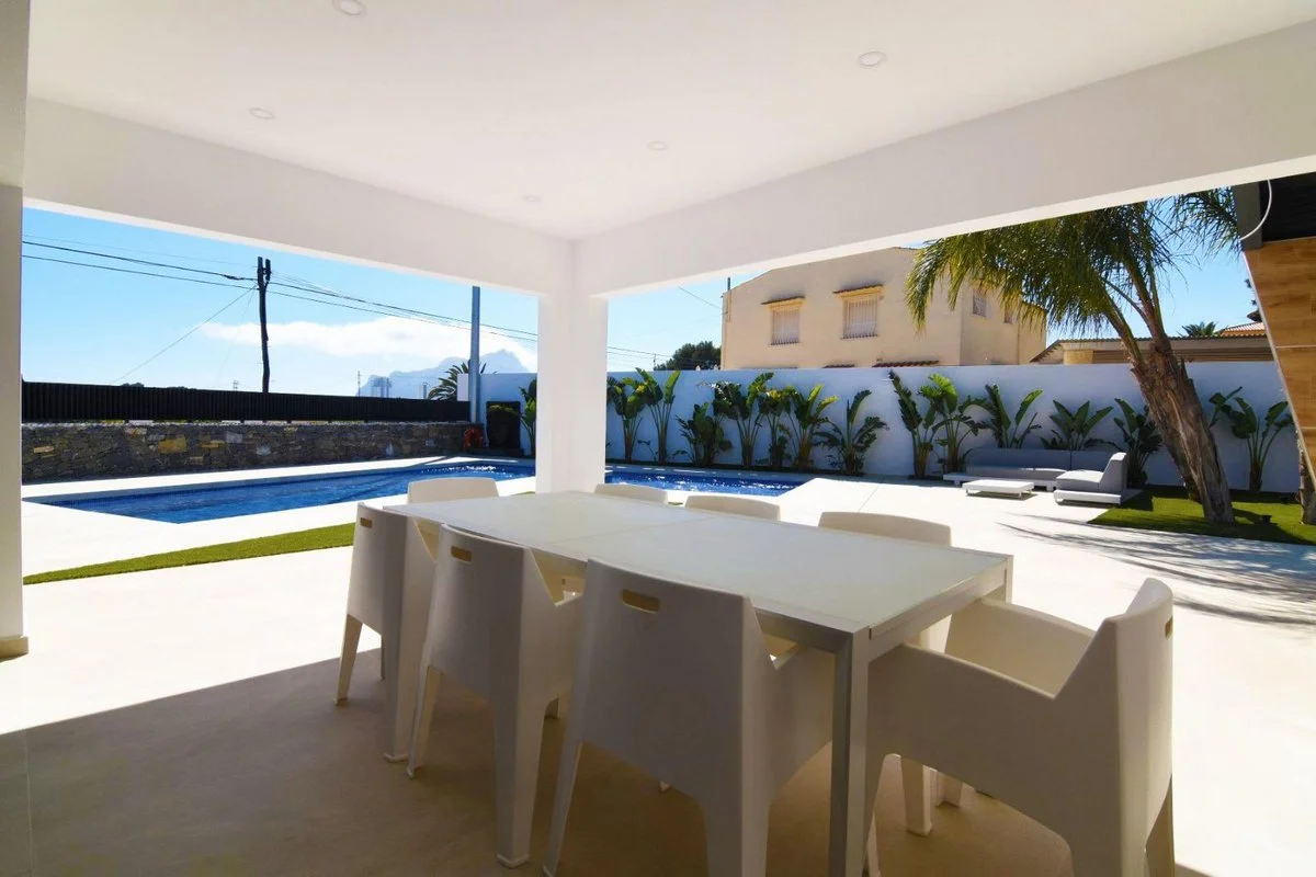 Covered terrace dining area overlooking the private pool at modern villa in Carrió, Calpe