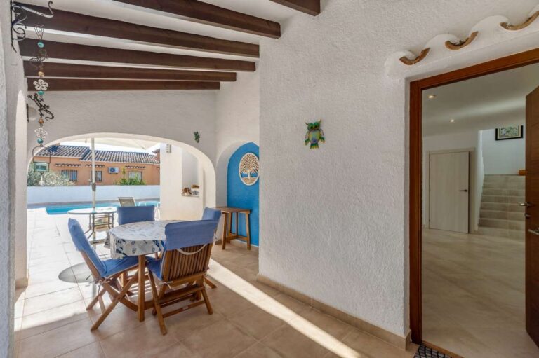 Covered terrace entrance with outdoor dining space at a contemporary villa in Calpe with private pool.