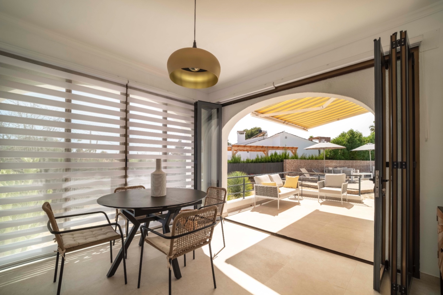 Covered terrace with dining area at Ibiza-style villa in Calpe