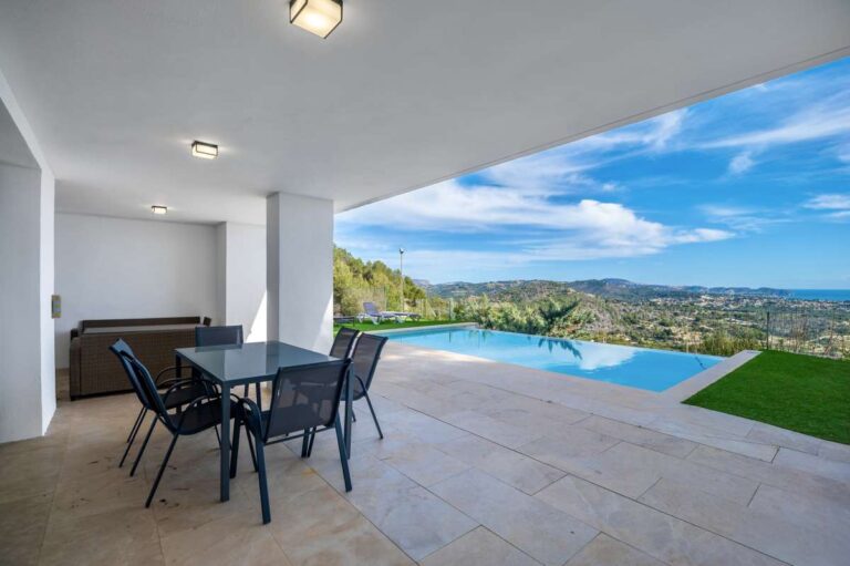 Covered terrace with outdoor dining area and panoramic sea views at a modern spacious villa in Calpe