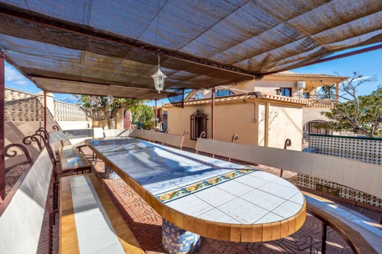 Covered terrace with outdoor dining area inside a spacious villa with guest apartments in Calpe.