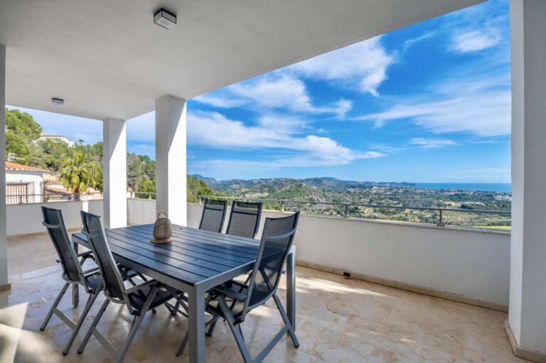 Covered terrace with outdoor dining space and open views at a modern spacious villa in Calpe.