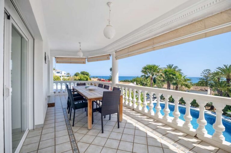 Covered terrace with outdoor seating and sea views at a villa in Calpe.