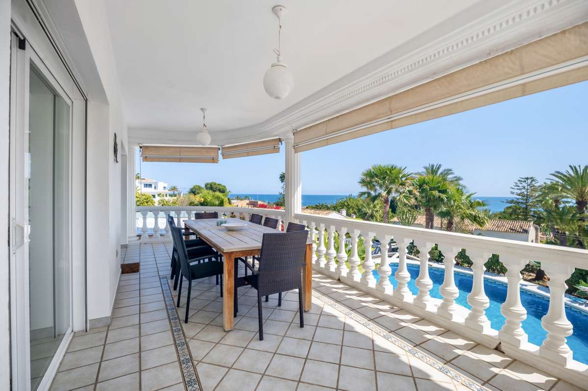 Covered terrace with outdoor seating and sea views at a villa in Calpe.