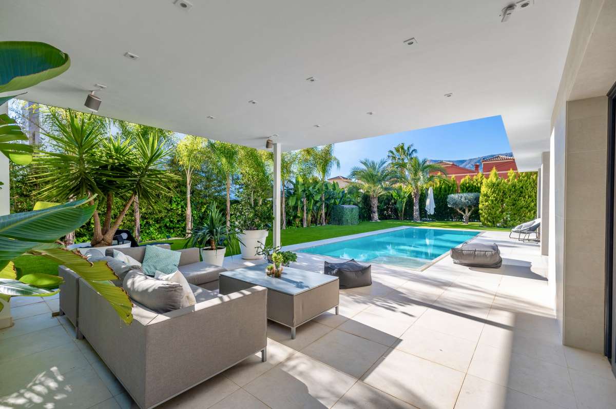 Covered terrace with outdoor seating and views across the private pool at a modern oasis villa in Calpe.