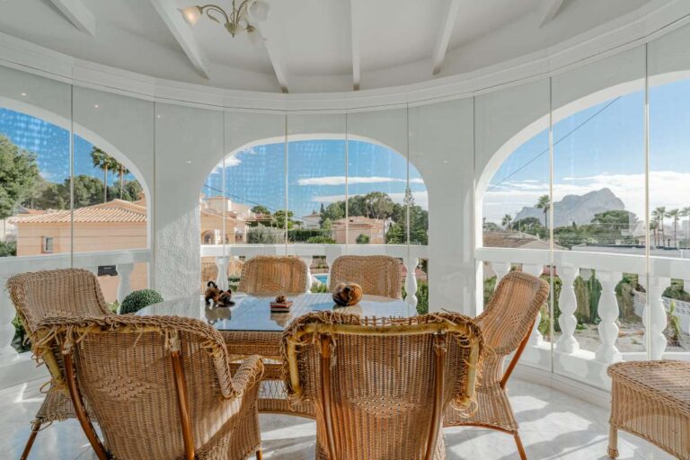 Covered terrace with traditional seating and views towards the Peñón de Ifach at a Mediterranean villa in Calpe.