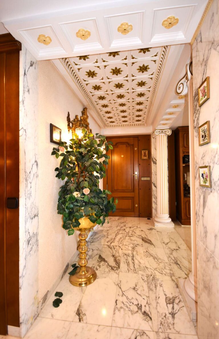Decorative entrance hall with marble flooring, columns and detailed ceiling inside a frontline double penthouse in Calpe.