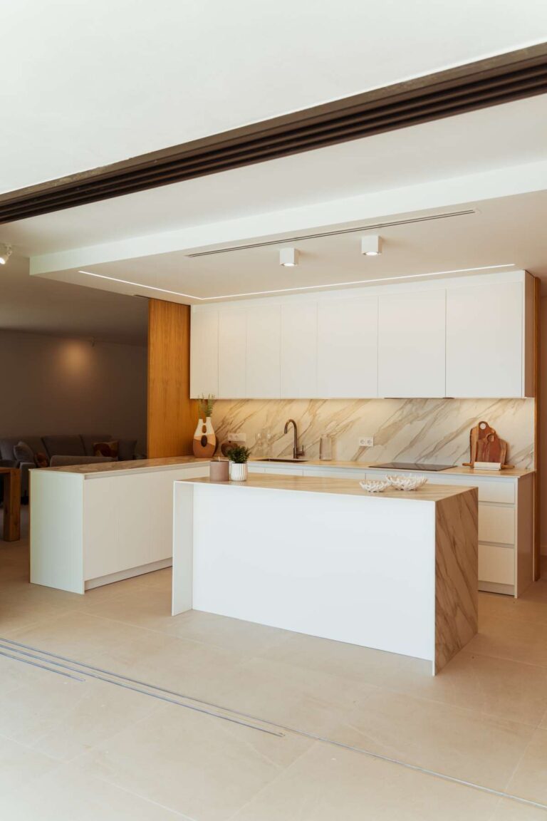 Designer kitchen inside a new-build luxury villa in Moraira with central island, white cabinetry, wood finish and integrated appliances