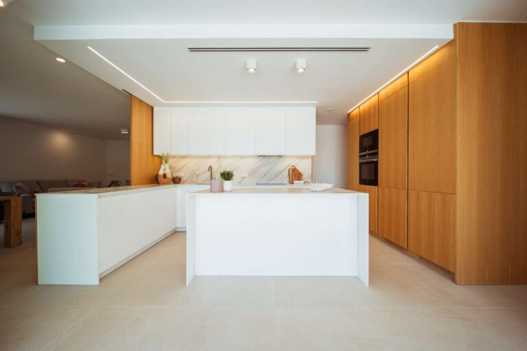 Designer kitchen inside a new-build luxury villa in Moraira with central island, wood cabinetry and integrated appliances