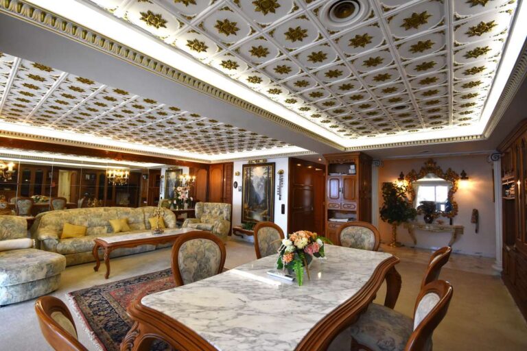 Dining and living area with custom-made furniture, decorative ceiling and quality finishes inside a frontline double penthouse on Arenal Beach.