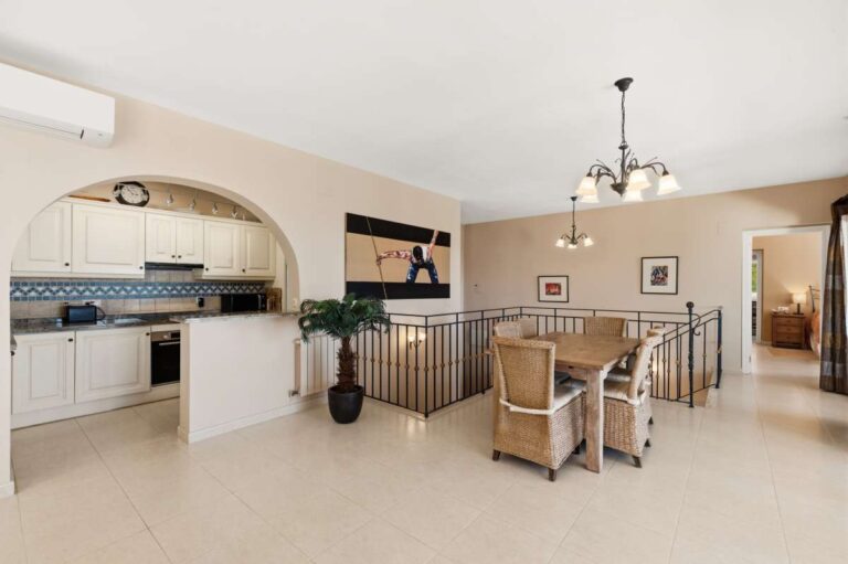 Dining area and kitchen inside an elegant Mediterranean villa in Altea Hills with open-plan layout, staircase and bright interior finish
