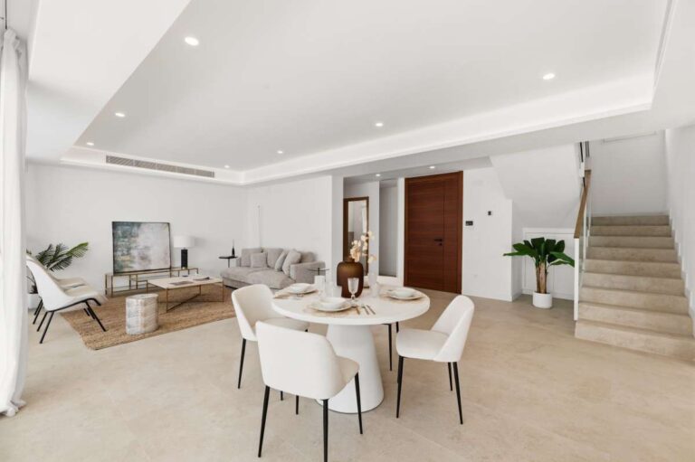Dining area and lounge inside a modern villa in Altea Hills with staircase access, sofa seating, large windows and bright interior design