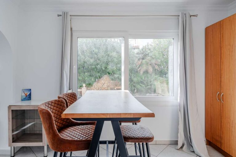Dining area in a Calpe villa with large window, tiled floor and built-in storage