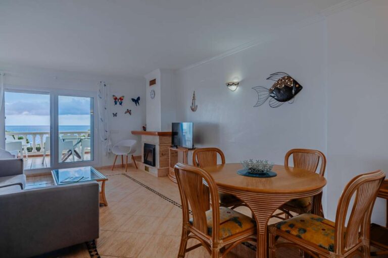 Dining area inside a duplex apartment near Les Platgetes Beach in Moraira with sea views, fireplace, terrace access and bright living space